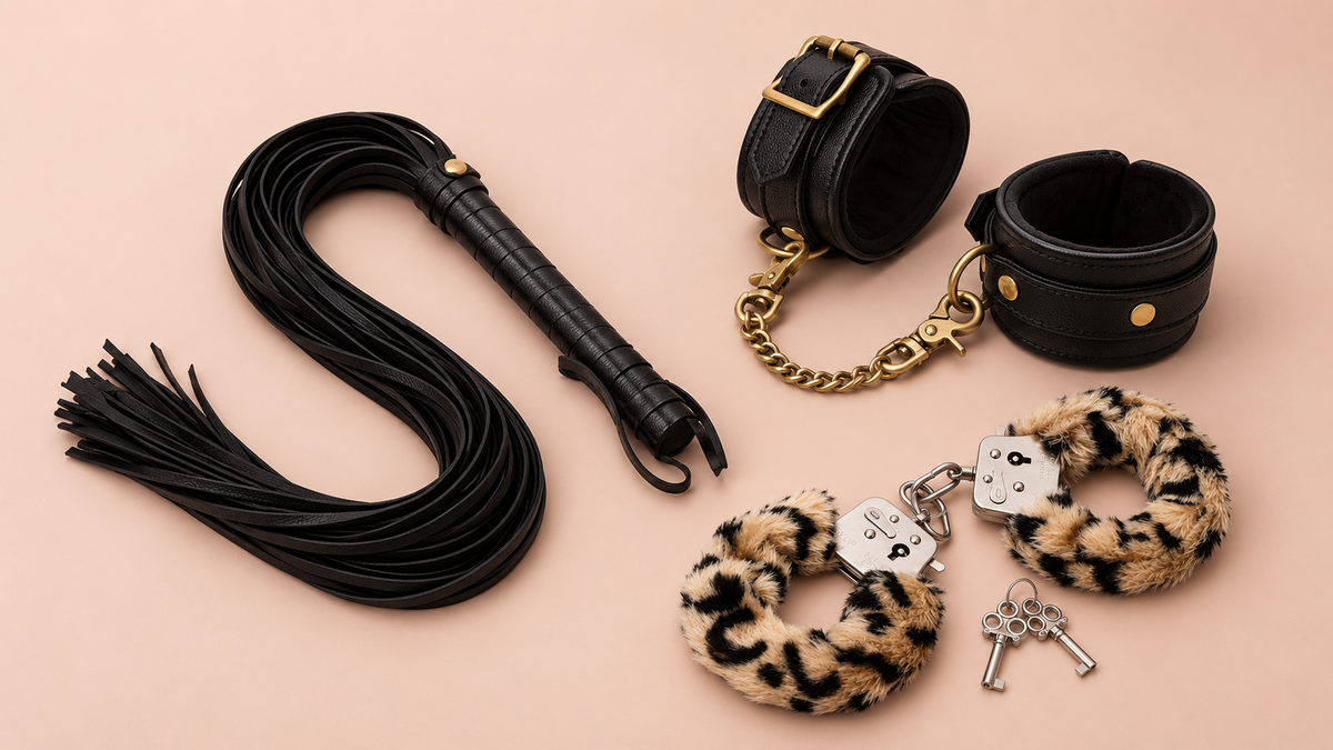 Soft bondage cuffs, blindfold and sensory-play accessories arranged on an elegant blush background