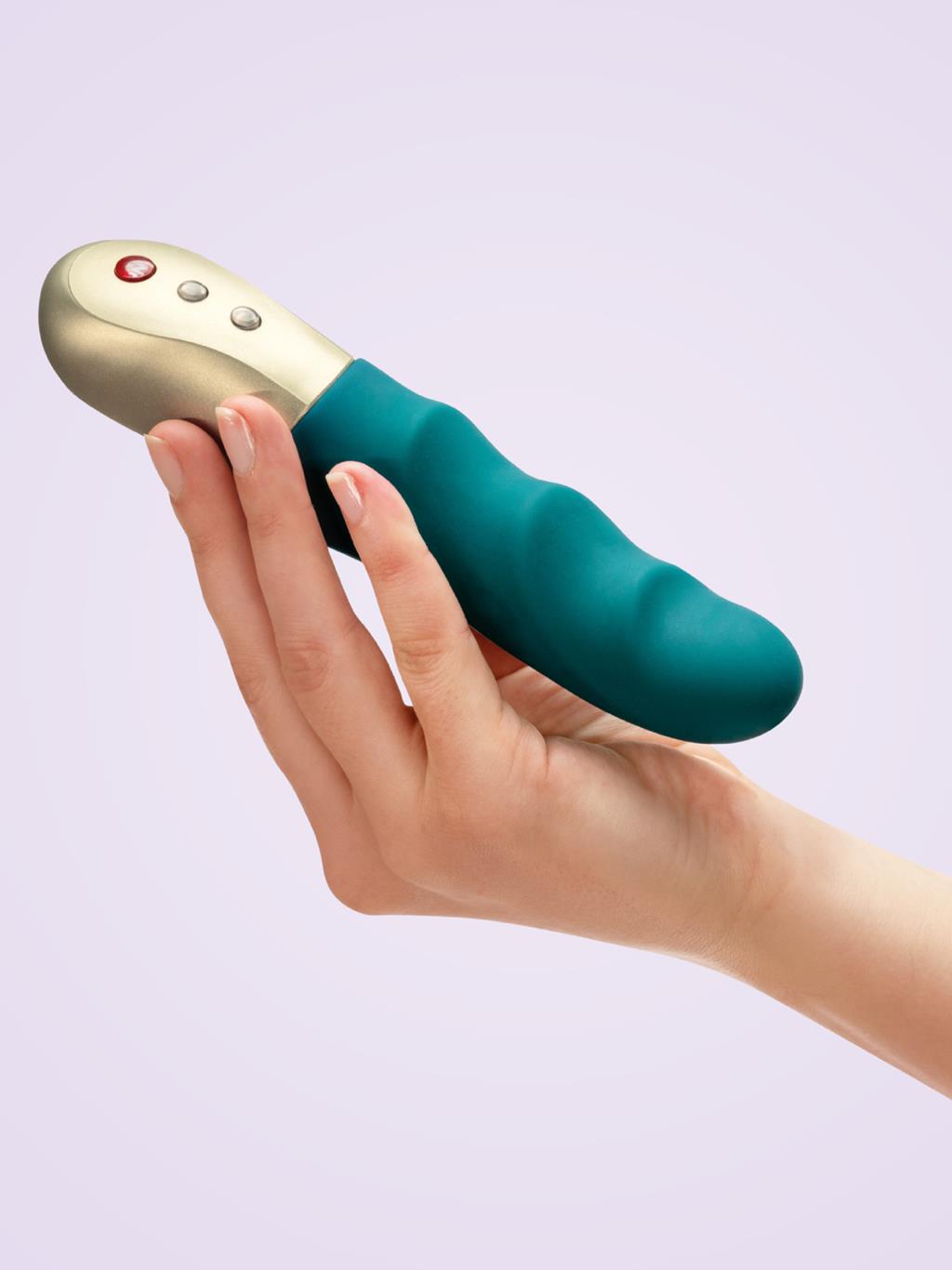 Hand holding Fun Factory Stronic Petite, showing compact size and sleek design