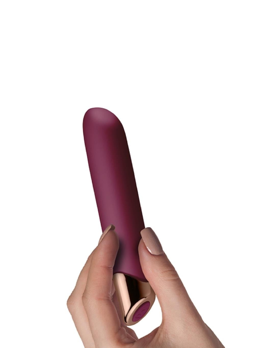 Hand holding the bullet vibrator, showing compact size and premium finish
