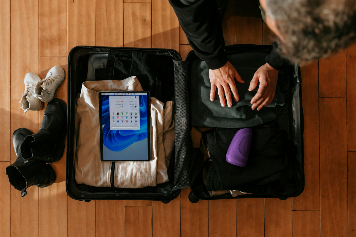 Compact travel-friendly sex toys and lubricant arranged with elegant travel accessories on a blush background